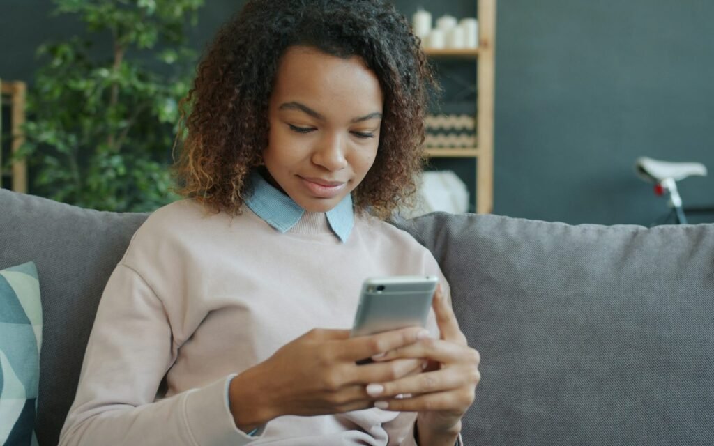 Mujer mirando el móvil sentada en el sofá