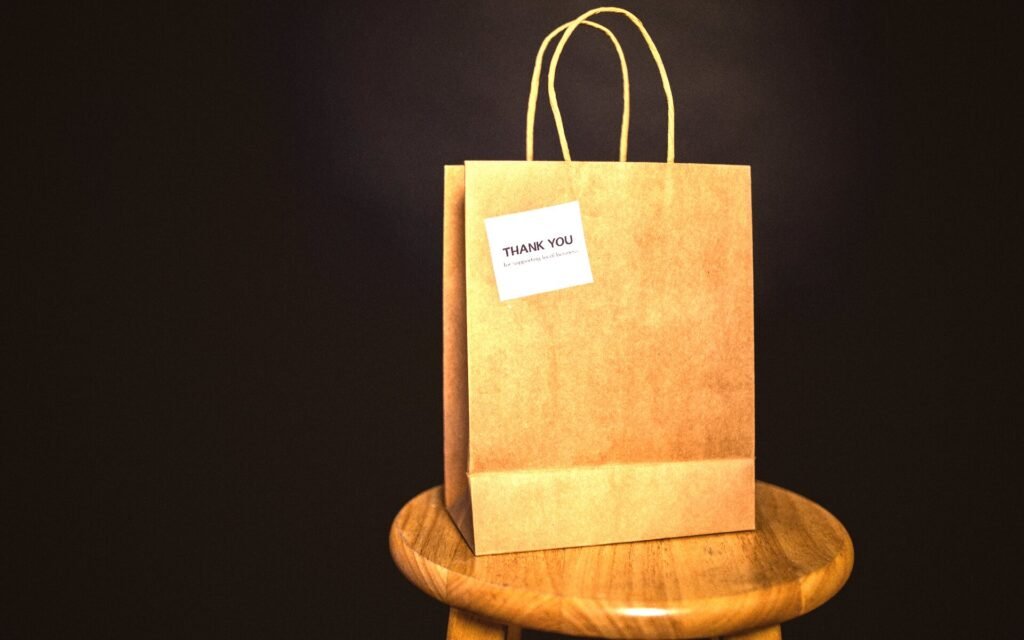 Bolsa de papel sola sobre un taburete de madera, sobre fondo oscuro